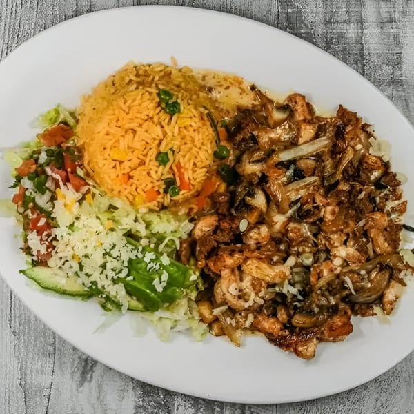 A Mexican dish with seasoned chicken and mushrooms, rice, and a fresh salad with avocado.